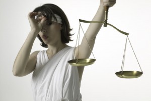 Woman dressed as lady justice peeking at scales